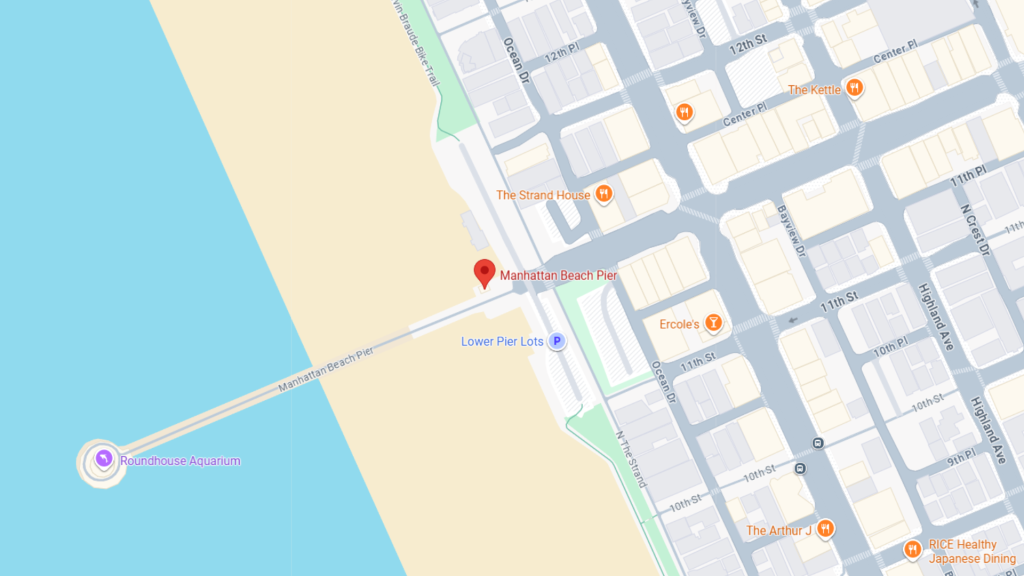 Map showing Manhattan Beach Pier along the coast near The Strand, with nearby restaurants and the Roundhouse Aquarium nearby.