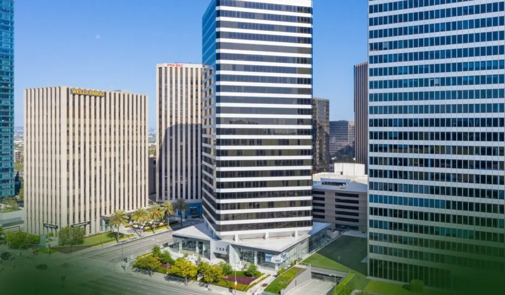 A city street surrounded by tall modern office towers; Wells Fargo Building visible on the left.