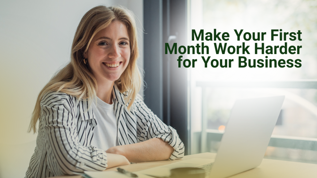 Barrister Suites Office Lease A smiling woman sits at a desk with a laptop, looking at the camera. Text beside her reads, Make Your First Month Work Harder for Your Business. Sunlight comes through a window in the background.