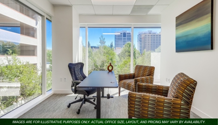 Barrister Suites Office Lease A modern private office with large windows, a black desk, an ergonomic chair, two patterned guest chairs, and a colorful abstract painting on the wall. City buildings and trees are visible outside.
