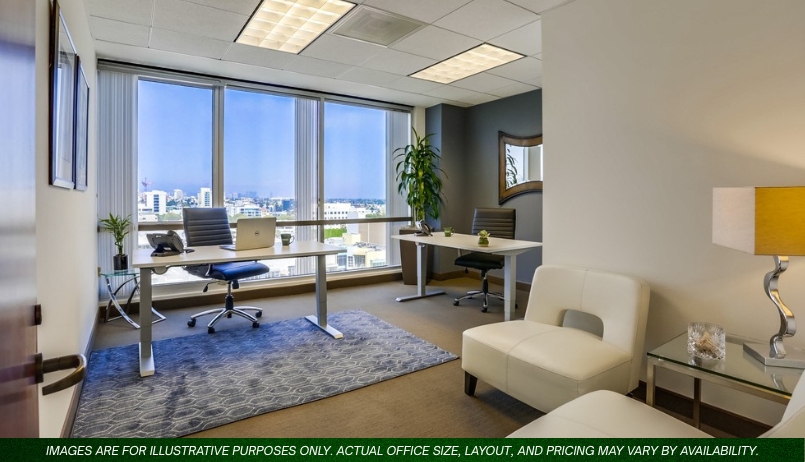 Barrister Suites Office Lease Modern office with two desks, chairs, a computer, and a laptop by large windows overlooking a cityscape. There is a white sofa, a small table with a lamp, and a potted plant in the corner.