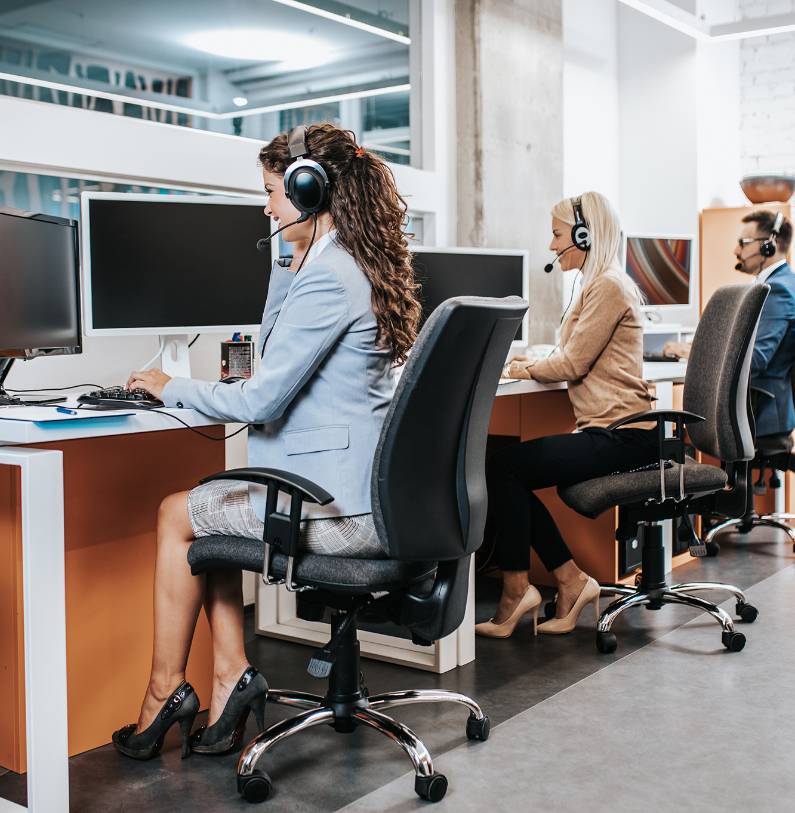 Barrister Suites Office Lease Three people wearing headsets sit at desks with computers in a modern office, focused on their work. The environment looks professional and collaborative.