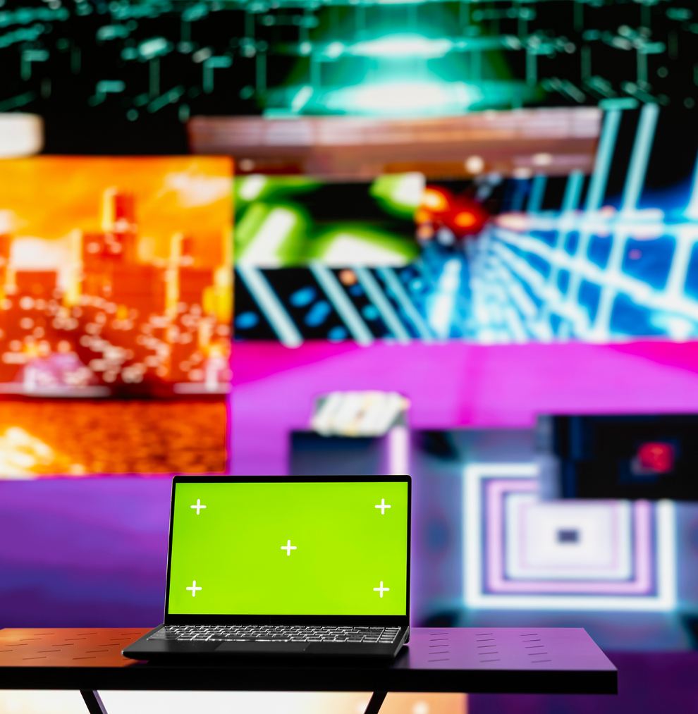 Barrister Suites Office Lease A laptop with a green screen sits on a table in front of a colorful, futuristic digital background featuring geometric shapes and vibrant cityscape images.