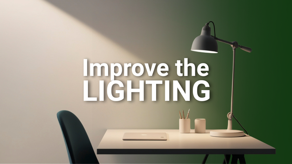 Barrister Suites Office Lease A desk with a laptop, pencils, and a lamp shining light, casting a shadow. Text on the image reads: Improve the LIGHTING.
