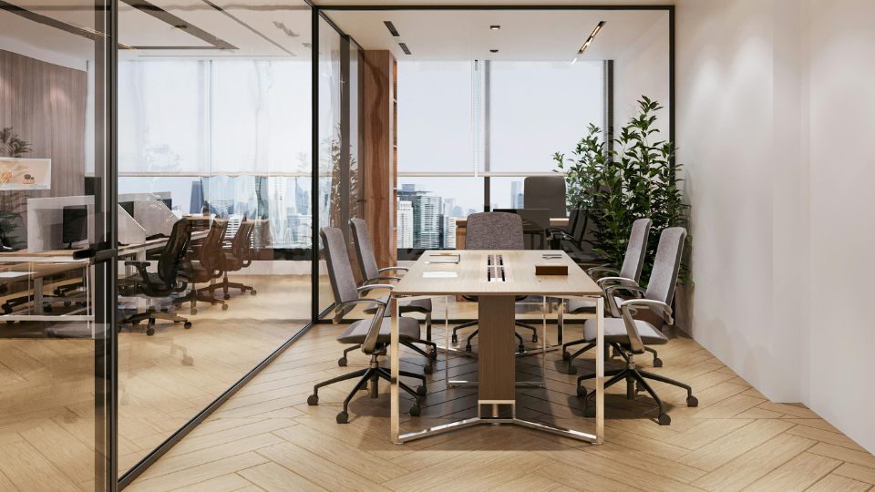 Barrister Suites Office Lease Modern conference room with a wooden table, six gray chairs, large windows with a city view, glass walls, indoor plants, and natural lighting. Another office space is visible through the glass partition.
