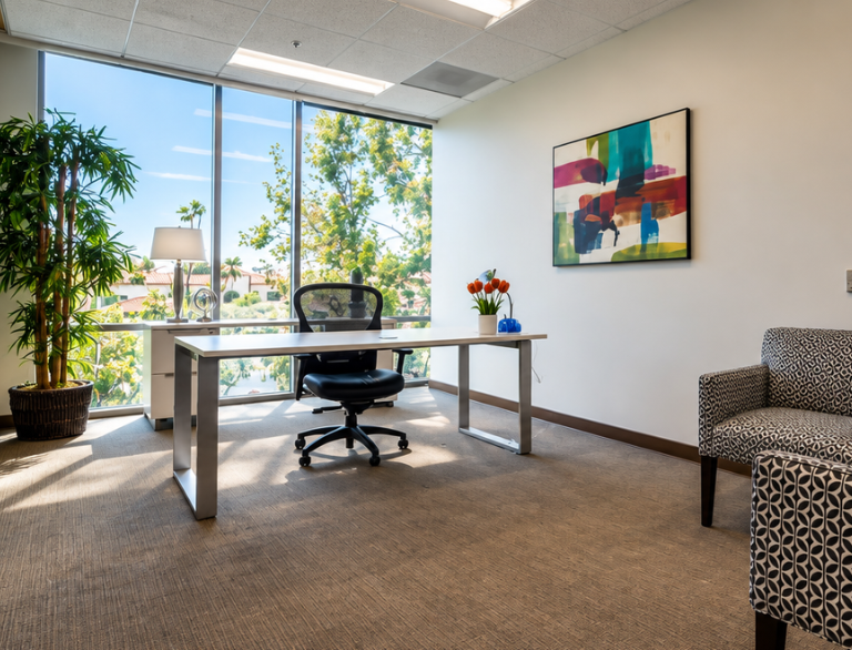 Barrister Suites Office Lease A modern office with a large window, desk, black chair, potted plant, tulips in a vase, abstract wall art, and a patterned armchair. Sunlight streams in, illuminating the space.